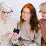 Three senior women looking at a smartphone