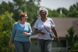 Two older women walking and laughing together