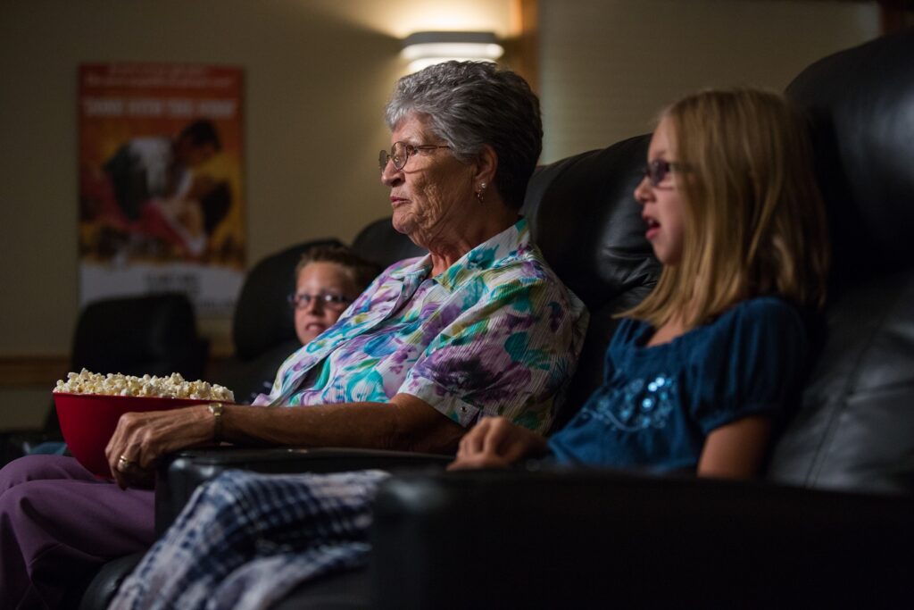 Older woman with two younger children with a bowl of popcorn