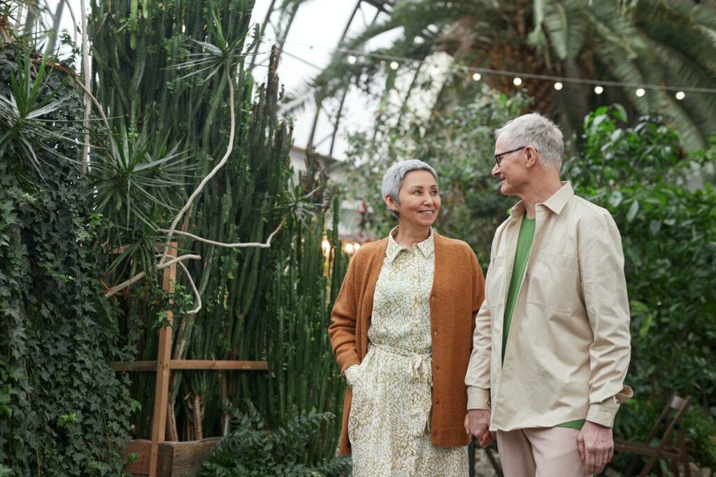 Older couple holding hands taking a walk in an outdoor garden