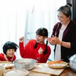 Older woman with two younger children cooking together