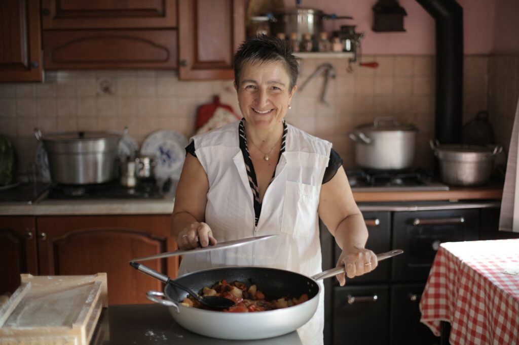 Older woman cooking nutritious meal in kitchen.
