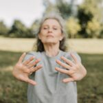 Older senior woman with arthritis holding yoga mat