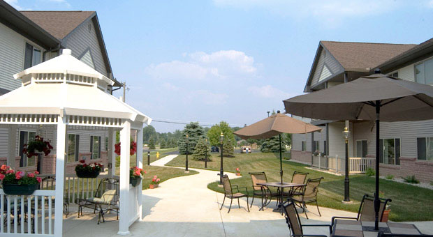 Sweetwater Retirement's beautiful outdoor patio with umbrella covered tables and a gazebo.