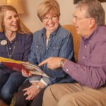 Younger woman and senior couple laughing together